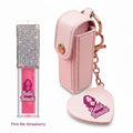 Bella Beauté pink lip oil with a rhinestone-covered cap and a pink keychain holder with a heart-shaped charm.
