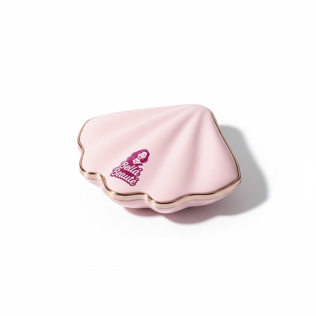 Bella Beauté blush compact in a pink seashell shape with gold trim and logo.