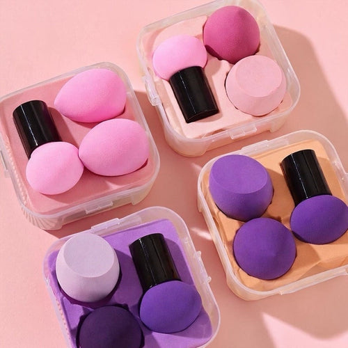 Bella Beauté makeup sponges in pink and purple, featuring various shapes for blending foundation and concealer. Includes travel cases.