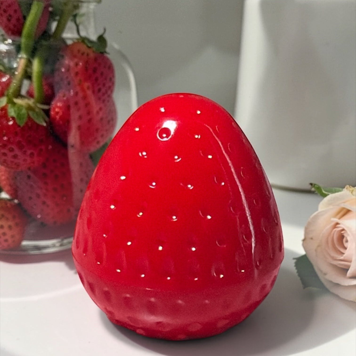 Bella Beauté Strawberry Glow Lip Balm Tint in cute strawberry-shaped packaging, providing natural red tint and hydration.